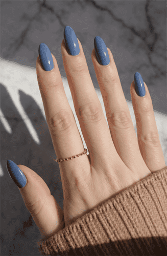Dusty blue almond-shaped nails with glossy finish on long natural nails, minimalist solid color manicure in soft neutral tone