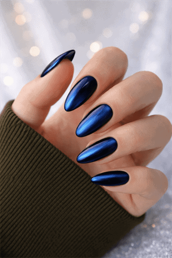 Metallic navy blue chrome almond nails with mirror finish on long elegant manicure against soft bokeh background