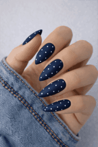 Matte navy blue almond nails with white polka dot design, minimalist long nail art with clean modern finish