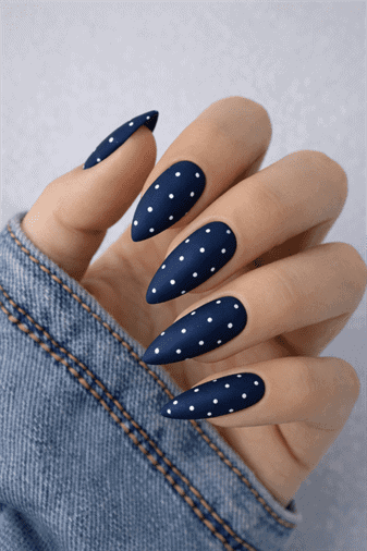 Matte navy blue almond nails with white polka dot design, minimalist long nail art with clean modern finish