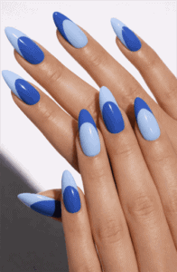 Blue ombre almond nails with alternating light and dark shades and angled French tip accents on long glossy manicure