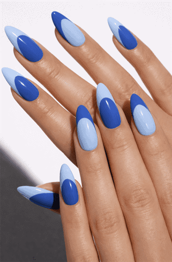 Blue ombre almond nails with alternating light and dark shades and angled French tip accents on long glossy manicure