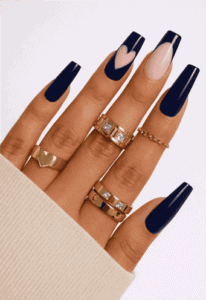 Dark navy blue coffin nails with glossy finish and nude accent nail featuring pink heart design, long acrylic manicure