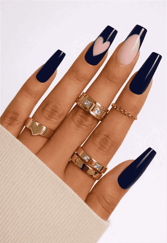 Dark navy blue coffin nails with glossy finish and nude accent nail featuring pink heart design, long acrylic manicure