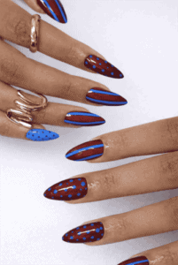 Brown and blue abstract almond nails with glossy finish featuring polka dots and striped nail art design on long nails