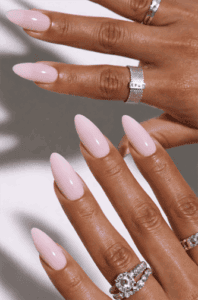Long almond-shaped nails with soft milky pink nude polish, glossy finish with smooth high-shine surface, clean minimalist neutral manicure with elegant everyday aesthetic
