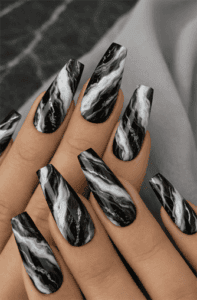Long coffin-shaped nails with black and white marble swirl design, high-gloss finish, bold contrast pattern on sleek modern statement nails
