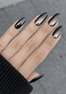 Medium almond-shaped nails with mirror chrome black finish, ultra-glossy reflective metallic effect, sleek minimalist high-shine futuristic nail design