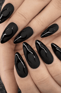 Long almond nails with matte black base and glossy black flame accents, tonal contrast design with edgy modern aesthetic and textured finish