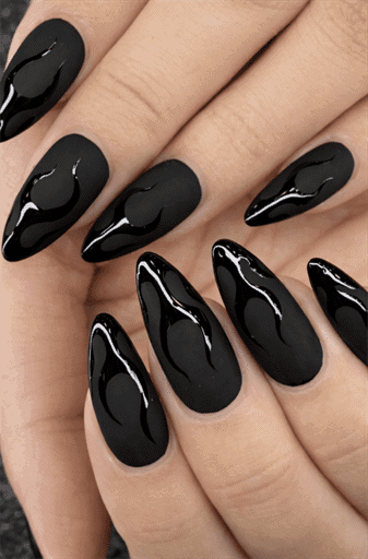 Long almond nails with matte black base and glossy black flame accents, tonal contrast design with edgy modern aesthetic and textured finish