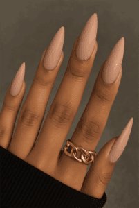 Long almond-shaped nails with soft matte nude finish, smooth velvety texture with minimalist aesthetic, modern neutral nail design for everyday wear