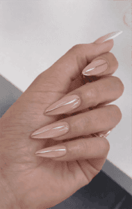 Long stiletto nails with nude base and thin gold line accents, sleek minimalist design with glossy finish and subtle luxury detail