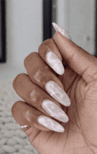 Long almond nails with milky white base and soft marble veining, glossy finish with subtle translucent effect and elegant minimalist design