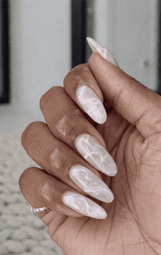 Long almond nails with milky white base and soft marble veining, glossy finish with subtle translucent effect and elegant minimalist design