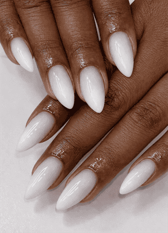 Long almond nails with milky white ombre gradient over nude base, glossy finish with soft blended transition and clean neutral aesthetic