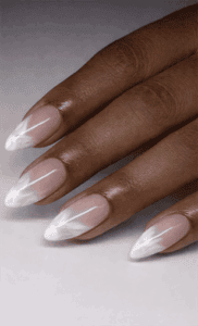 Almond-shaped nails with nude base and white marble French tips, glossy finish with delicate veining detail and elevated minimalist design