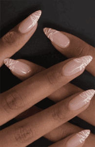 Almond-shaped nails with nude base and fine white zebra stripe detailing on tips, glossy finish with subtle animal print and modern minimalist nail design