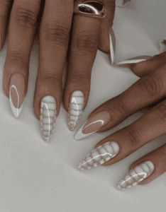 Long almond nails with nude base and black and white animal print French tips, glossy finish with bold contrast and trendy statement design