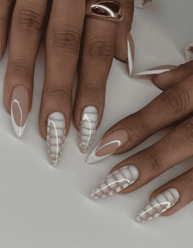 Long almond nails with nude base and black and white animal print French tips, glossy finish with bold contrast and trendy statement design