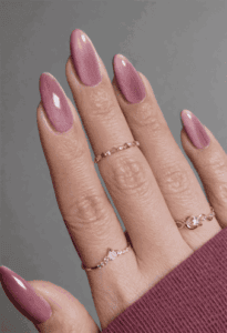 Almond-shaped nails with dusty rose chrome cat eye effect, magnetic shimmer finish with reflective depth and sleek metallic gradient nail design