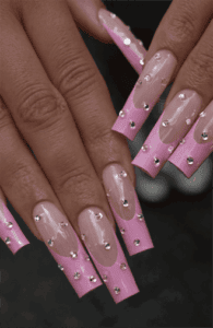 Long square nails with pink French tips over nude base, embellished with rhinestones for added sparkle, glossy finish with bold glam statement design