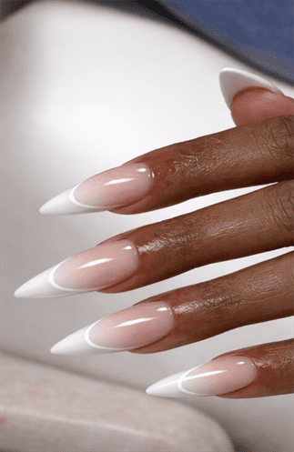 Long almond nails with soft nude to white French ombre gradient, seamless blend with glossy finish and clean modern bridal nail aesthetic