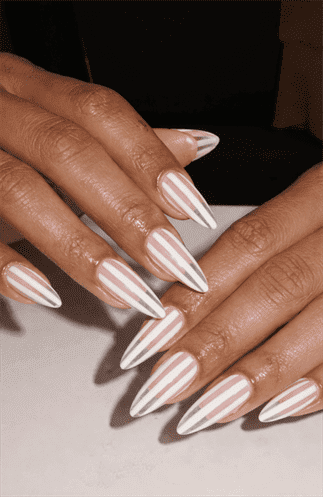 Long almond nails with nude base and vertical white stripe pattern, glossy finish with clean linear design and modern minimalist aesthetic