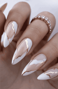 Almond-shaped nails with nude base and white marble French tips accented with gold detailing, glossy finish with luxury modern nail design