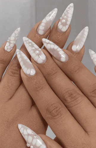 Long stiletto nails with milky white pearl finish and soft bubble texture accents, glossy translucent effect with dimensional modern nail design