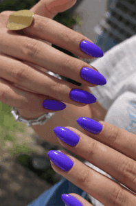 Royal purple almond nails with glossy finish, bold solid color manicure on long nails