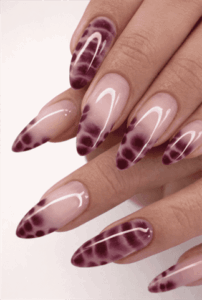 Burgundy purple ombre almond nails with abstract aura fade design on glossy nude base, modern gradient nail art