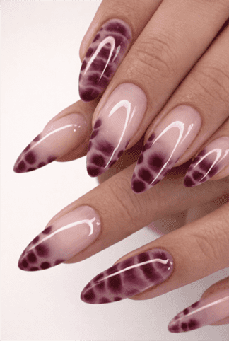 Burgundy purple ombre almond nails with abstract aura fade design on glossy nude base, modern gradient nail art