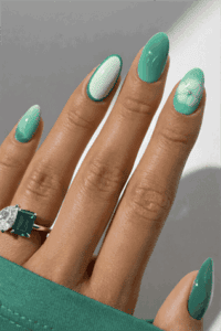 Mint and emerald green almond nails with mix and match design, glossy manicure with floral and gradient accents