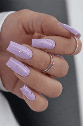Lilac rhinestone coffin nails with glossy finish, pastel purple nail design with crystal accents on long nails
