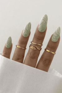 Mint green swirl almond nails with glossy finish, soft marble-inspired nail design on long elegant manicure