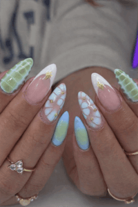 Pastel aura almond nails with blue and green ombre, 3D textured nail art, gold accents and glossy finish on long nails