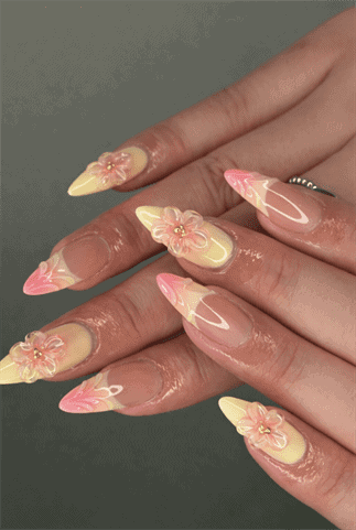 Pastel floral 3D almond nails with pink and yellow ombre tips, glossy nude base and sculpted flower nail art