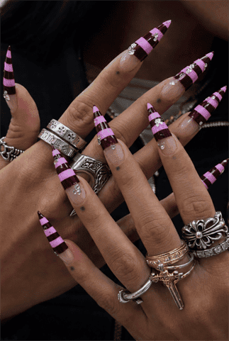 Pink and burgundy striped stiletto nails with rhinestones, glossy long pointed statement nail design