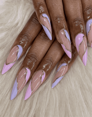 Pink and lilac French tip stiletto nails with gold line accents, glossy nude base long nail design