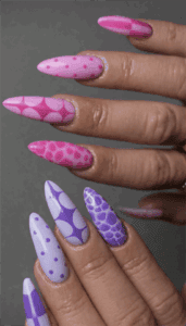 Pink and purple patterned almond nails with polka dots, checkerboard and abstract designs, glossy long manicure