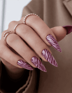 Purple zebra print stiletto nails with glossy finish, burgundy and white animal print nail art on long pointed nails