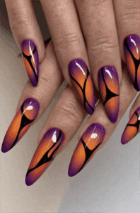 Purple and orange flame gradient stiletto nails with glossy finish, abstract ombre nail design on long nails