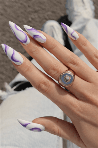 White and purple swirl stiletto nails with glossy finish, abstract wave nail art on long pointed nails