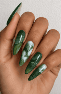 Emerald green marble stiletto nails with jade stone effect, glossy gemstone-inspired nail design featuring translucent green and white marbling