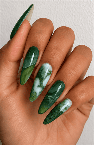 Emerald green marble stiletto nails with jade stone effect, glossy gemstone-inspired nail design featuring translucent green and white marbling