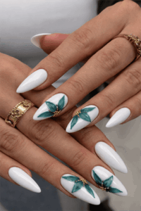 Glossy white almond nails with teal floral nail art and gold embellishments, elegant long manicure with detailed flower design