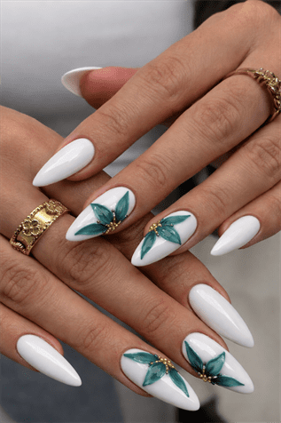 Glossy white almond nails with teal floral nail art and gold embellishments, elegant long manicure with detailed flower design