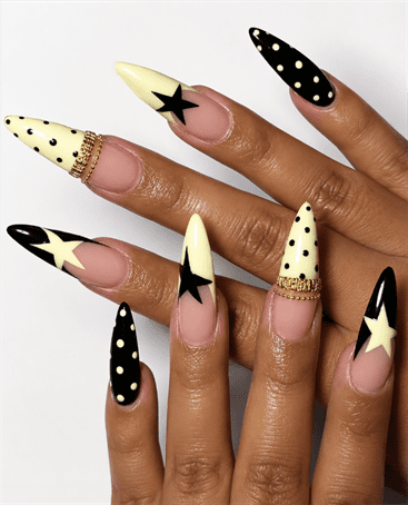 Black and butter yellow star stiletto nails with polka dot accents, retro graphic nail design on nude base