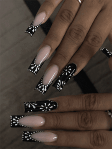 Black floral French tip coffin nails with nude base, glossy monochrome flower nail design on long acrylic nails