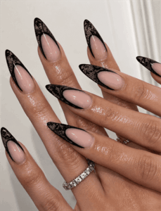 Black lace French tip stiletto nails with nude base, elegant gothic nail design with glossy finish